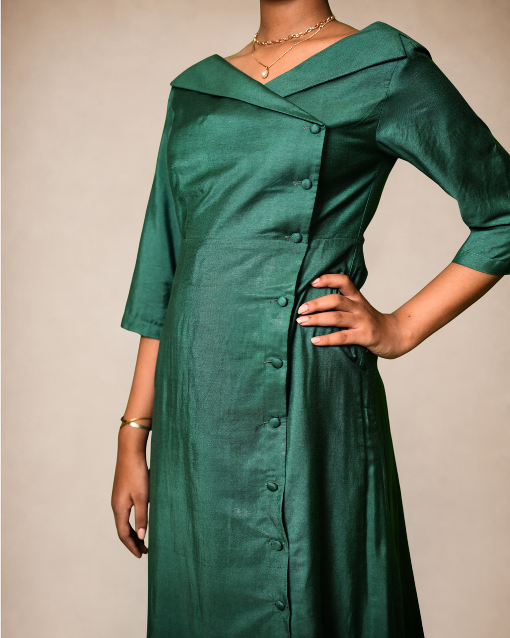  dark green wrap-style dress with three-quarter sleeves and a button front