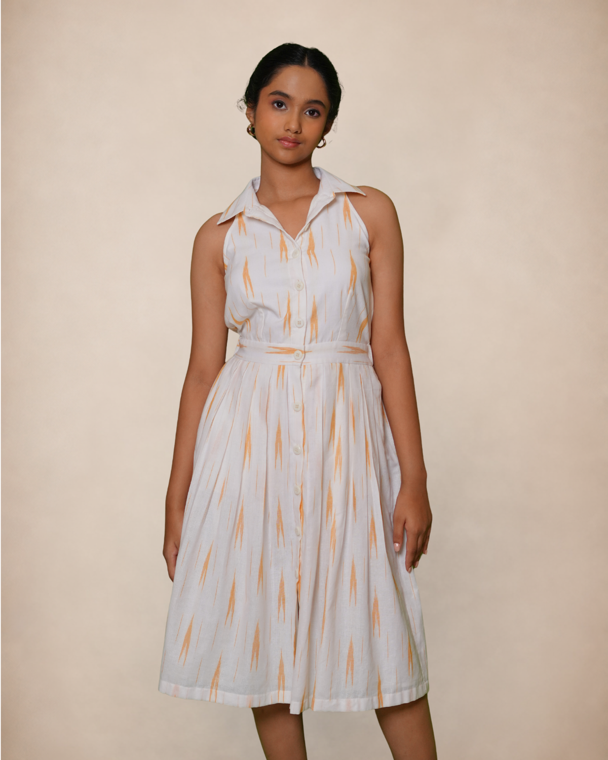 white collared dress with a matching waist tie, featuring a subtle orange and yellow ikat pattern handloom cotton summer dress